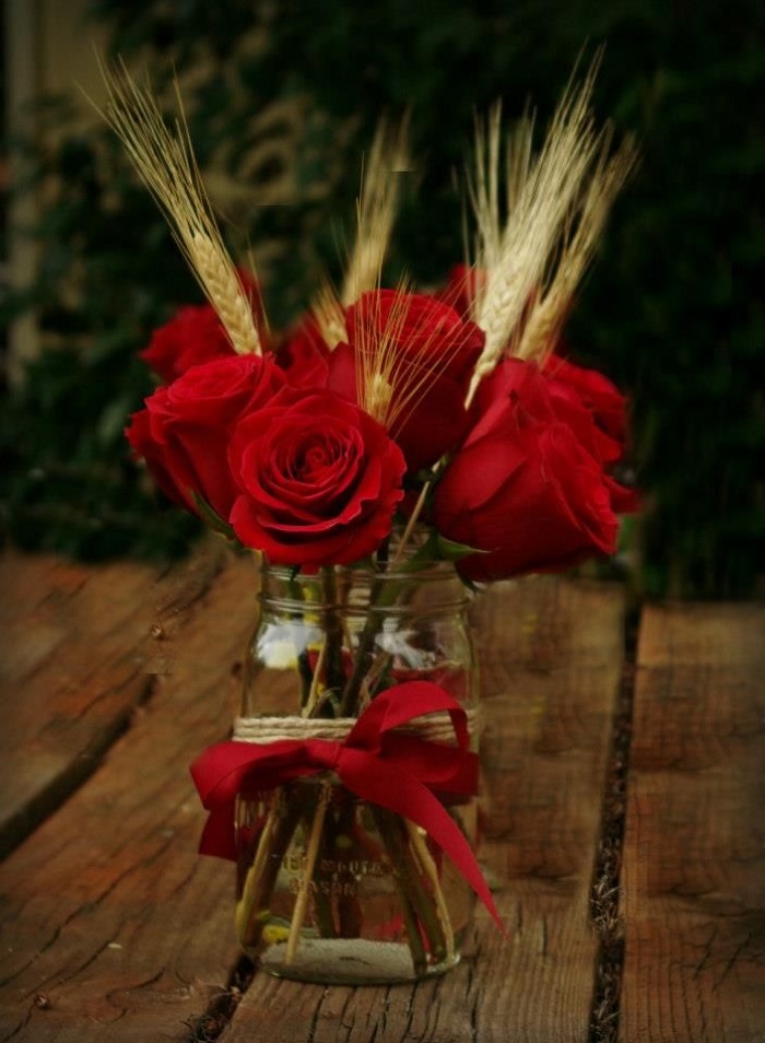 gold candle holders and burgundy flower bouquet in mason jars