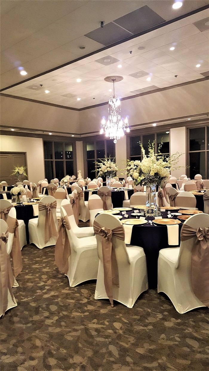 reception chairs with gold and burgundy colored ribbons