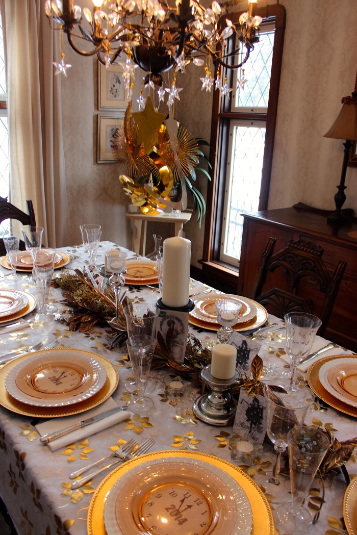 pair clock plates with a bowl filled with golden baubles.