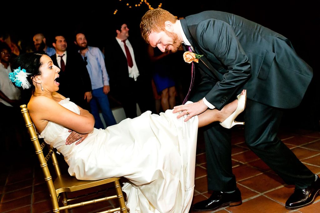 Groom Removes the garter -123WeddingCards